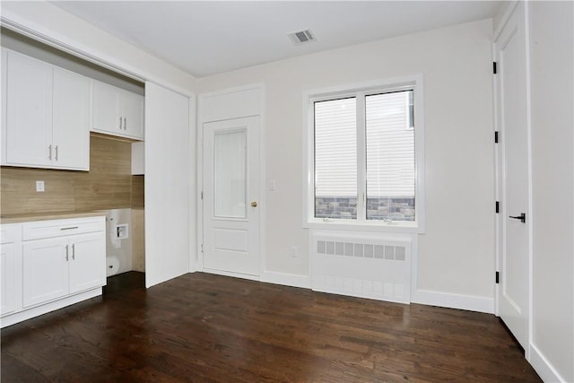 33 Ewing Ave Unit 102, Spring Valley, NY 10977 - kitchen featuring radiator heating unit, dark wood-style floors, tasteful backsplash, and white cabinetry