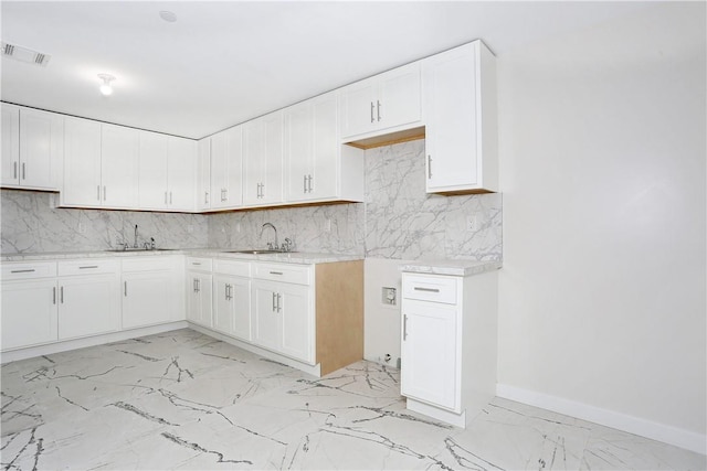 33 Ewing Ave Unit 102, Spring Valley, NY 10977 - kitchen featuring light marble finish flooring, decorative backsplash, and white cabinets