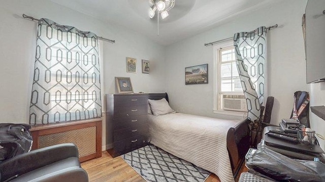 46-03 195th St, Flushing, NY 11358 - bedroom featuring light wood-style floors, radiator, cooling unit, and ceiling fan