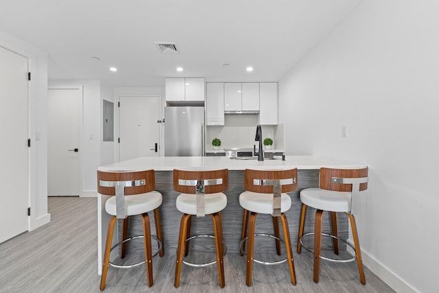 46-40 Vernon Blvd Unit 2A, Long Island City, NY 11101 - kitchen with freestanding refrigerator, modern cabinets, white cabinets, electric panel, and a kitchen bar