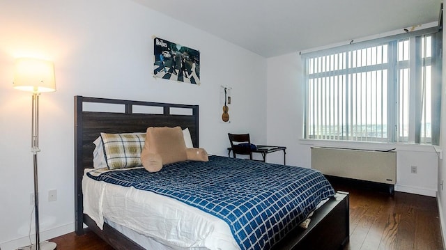 40-26 College Point Blvd Unit 15C, Flushing, NY 11354 - bedroom featuring radiator heating unit, multiple windows, and wood finished floors