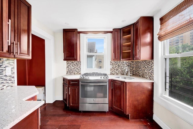 1519 Rosedale Ave, Bronx, NY 10460 - kitchen featuring stainless steel gas stove, decorative backsplash, glass insert cabinets, dark wood-style floors, and light stone counters