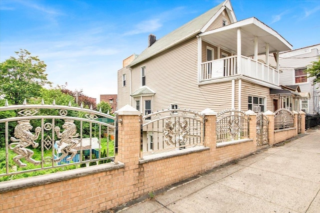 1519 Rosedale Ave, Bronx, NY 10460 - view of side of property featuring a gate, a balcony, a fenced front yard, and a chimney
