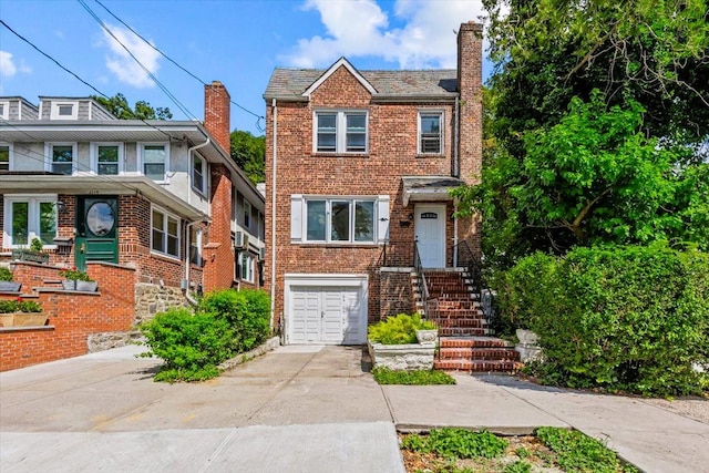 6112 Fieldston Rd, Bronx, NY 10471 - view of front facade featuring concrete driveway, an attached garage, brick siding, and a chimney