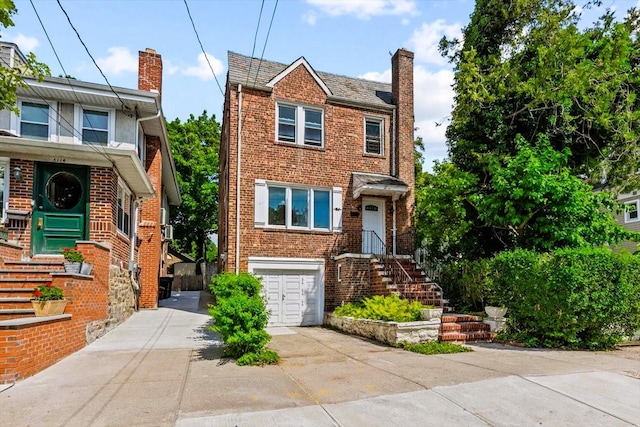 6112 Fieldston Rd, Bronx, NY 10471 - view of front of property with driveway, a chimney, an attached garage, and brick siding