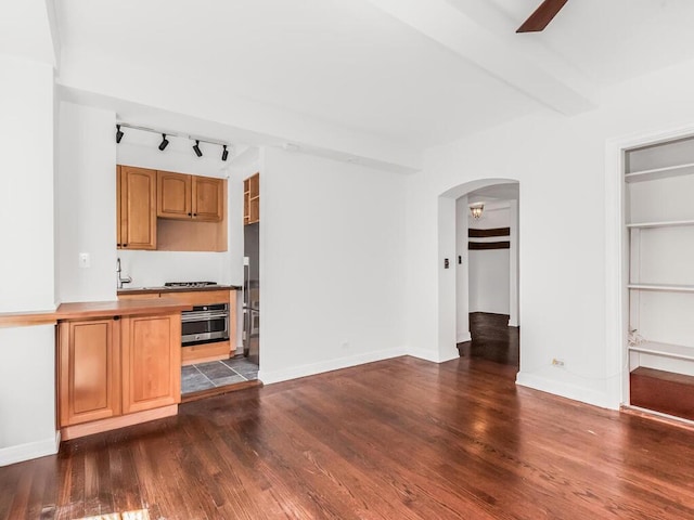 340 W 57th St Unit 5F, New York Manhattan, NY 10019 - bar area with a ceiling fan, appliances with stainless steel finishes, dark wood-style floors, arched walkways, and track lighting