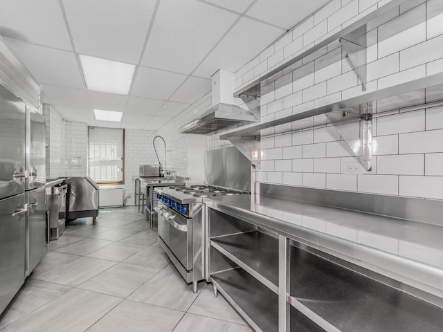 340 W 57th St Unit 5F, New York Manhattan, NY 10019 - kitchen with stainless steel counters, double oven range, a paneled ceiling, ventilation hood, and decorative backsplash