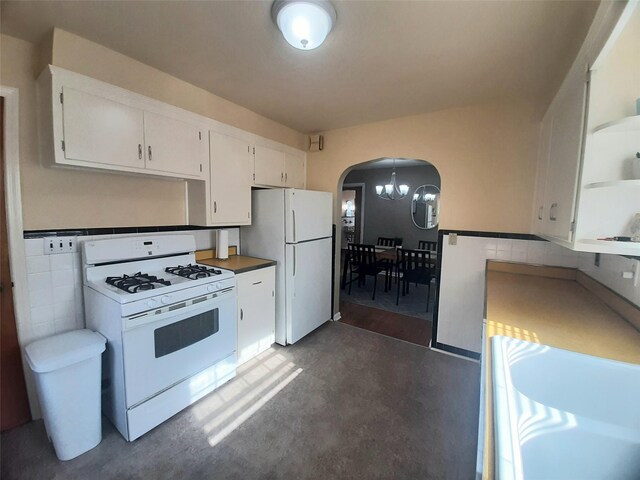52 Fountain Pl, Poughkeepsie, NY 12603 - kitchen featuring white appliances, arched walkways, white cabinetry, and a chandelier