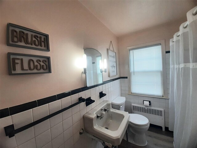 52 Fountain Pl, Poughkeepsie, NY 12603 - full bath featuring radiator heating unit, tile walls, wood finished floors, a shower with curtain, and a wainscoted wall