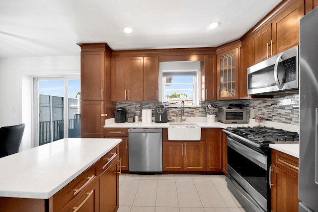 946 Balcom Ave, Bronx, NY 10465 - kitchen with stainless steel appliances, decorative backsplash, light tile patterned floors, brown cabinetry, and recessed lighting