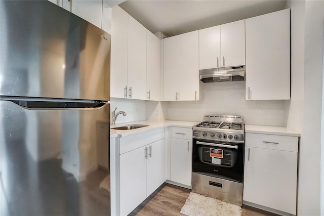 50-22 40th St Unit 2F, Sunnyside, NY 11104 - kitchen with stainless steel appliances, under cabinet range hood, light countertops, decorative backsplash, and light wood-style flooring