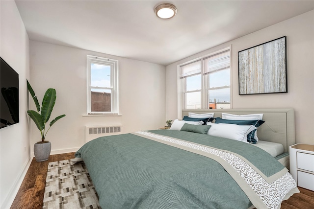 50-22 40th St Unit 2F, Sunnyside, NY 11104 - bedroom featuring radiator heating unit, multiple windows, and wood finished floors