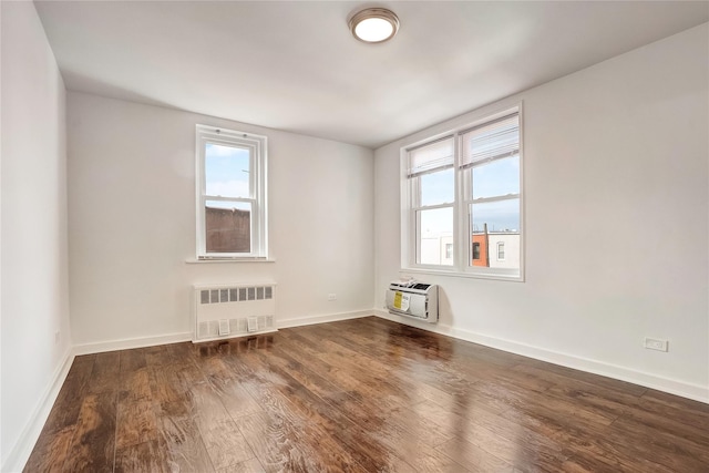 50-22 40th St Unit 2F, Sunnyside, NY 11104 - spare room with radiator heating unit, healthy amount of natural light, dark wood-type flooring, and an AC wall unit