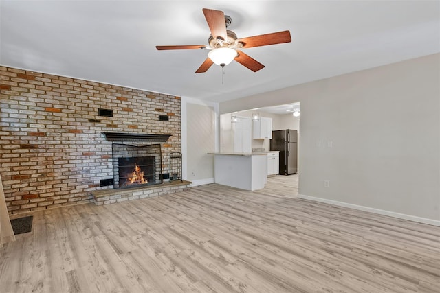 68 Gerald Dr Unit D1, Poughkeepsie, NY 12601 - unfurnished living room with a ceiling fan, a fireplace, light wood finished floors, and brick wall