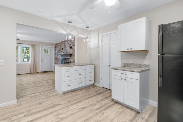 68 Gerald Dr Unit D1, Poughkeepsie, NY 12601 - kitchen with freestanding refrigerator, ceiling fan, white cabinets, a fireplace, and light wood finished floors