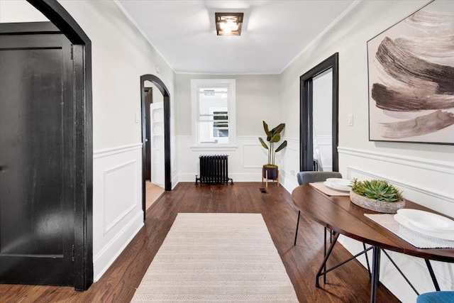4 Cedar St, Hastings-On-Hudson, NY 10706 - foyer featuring radiator heating unit, arched walkways, ornamental molding, wood finished floors, and a wainscoted wall