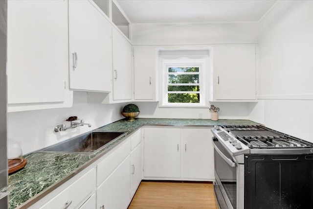 4 Cedar St, Hastings-On-Hudson, NY 10706 - kitchen with stainless steel gas stove, white cabinets, ornamental molding, and light wood-type flooring