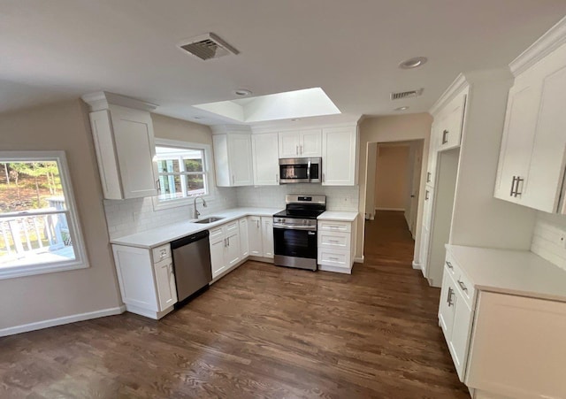 181 Wading River Hollow Rd, Ridge, NY 11961 - kitchen featuring stainless steel appliances, tasteful backsplash, and white cabinetry