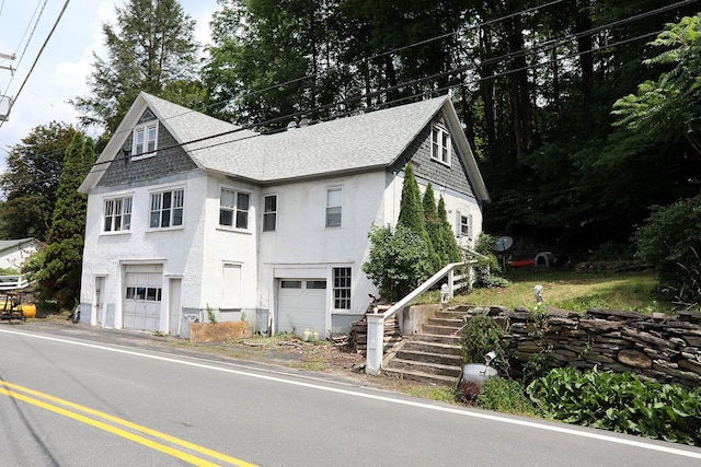11620 State Route 97, Long Eddy, NY 12760 - view of front of property featuring an attached garage, roof with shingles, stucco siding, and stairs