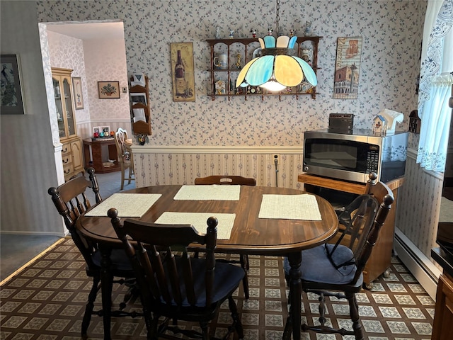 557 Southside Ave, Freeport, NY 11520 - dining area with wallpapered walls, baseboard heating, and wainscoting