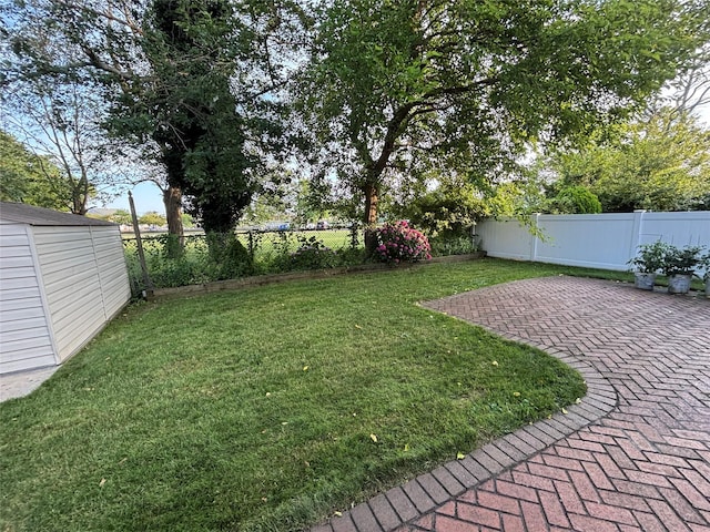 557 Southside Ave, Freeport, NY 11520 - fenced backyard featuring a patio area and a storage shed