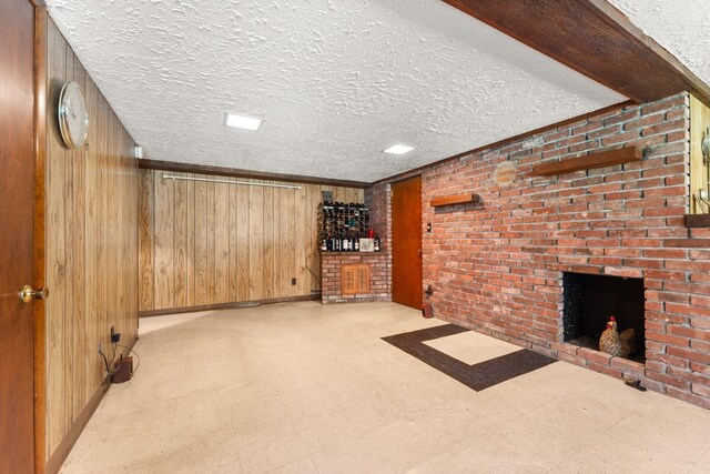 15 Glen Dr, South Salem, NY 10590 - unfurnished living room featuring tile patterned floors, a brick fireplace, wooden walls, and a textured ceiling