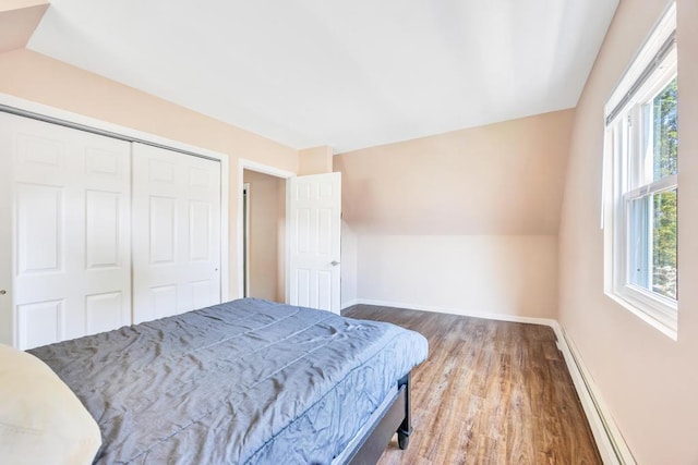 15 Halewood Dr, Shirley, NY 11967 - bedroom featuring baseboard heating, wood finished floors, lofted ceiling, and a closet