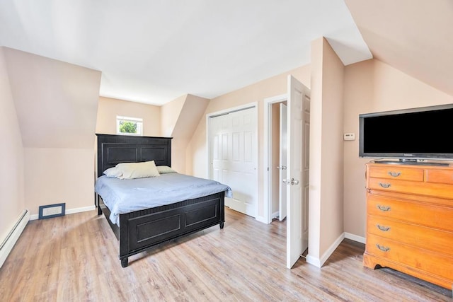 15 Halewood Dr, Shirley, NY 11967 - bedroom with a baseboard heating unit, light wood-type flooring, vaulted ceiling, and a closet