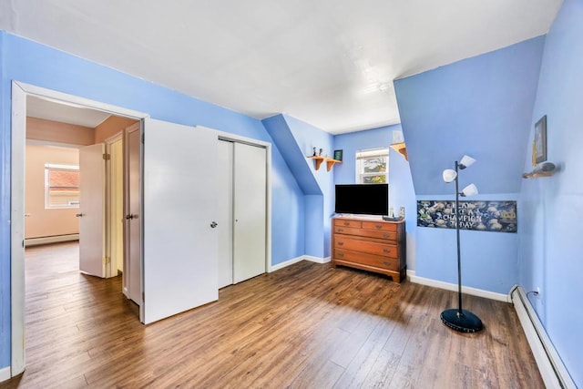 15 Halewood Dr, Shirley, NY 11967 - bedroom featuring baseboard heating, wood-type flooring, and a closet