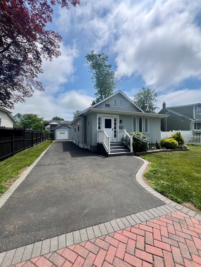 234 S 7th St, Lindenhurst, NY 11757 - bungalow-style house with asphalt driveway, an outbuilding, and board and batten siding