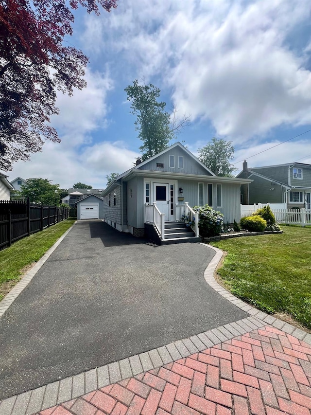 234 S 7th St, Lindenhurst, NY 11757 - bungalow featuring asphalt driveway, an outdoor structure, and board and batten siding