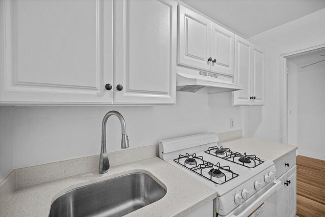 2102 Holland Ave Unit 6D, Bronx, NY 10462 - kitchen with white gas range oven, under cabinet range hood, white cabinetry, and light countertops