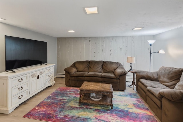 60 Wheatfield Ln, Commack, NY 11725 - living area with a baseboard heating unit, light wood-style floors, and wooden walls