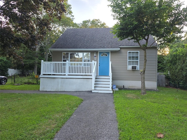 459 Wellwood Dr, Shirley, NY 11967 - view of front facade featuring a front lawn, roof with shingles, a porch, and cooling unit
