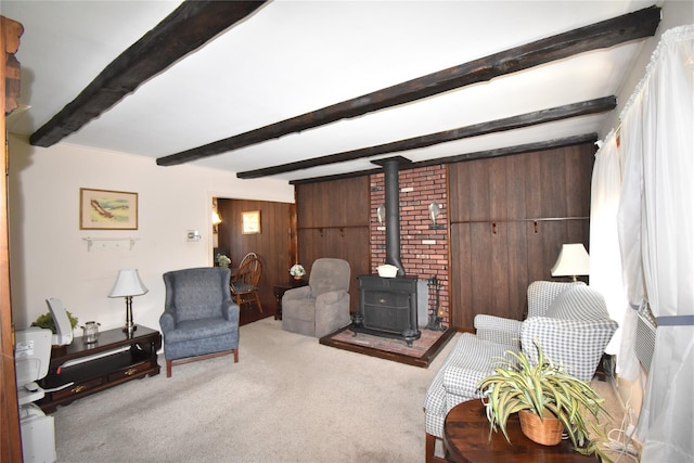 43 Circuit Rd, Bellport, NY 11713 - carpeted living room featuring a wood stove, beam ceiling, and wood walls