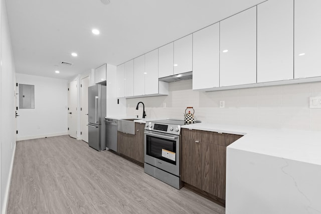 46-40 Vernon Blvd Unit 2B, Long Island City, NY 11101 - kitchen featuring appliances with stainless steel finishes, under cabinet range hood, white cabinetry, modern cabinets, and decorative backsplash