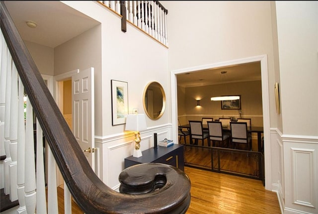 9 Roselawn Rd, Highland Mills, NY 10930 - staircase featuring a decorative wall, wood finished floors, wainscoting, and a high ceiling