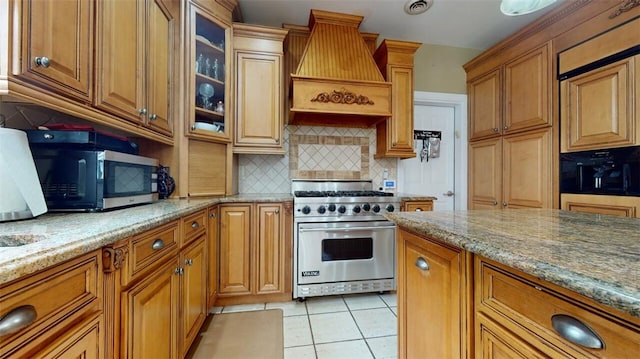 9 Roselawn Rd, Highland Mills, NY 10930 - kitchen featuring appliances with stainless steel finishes, custom exhaust hood, decorative backsplash, light tile patterned floors, and light stone countertops