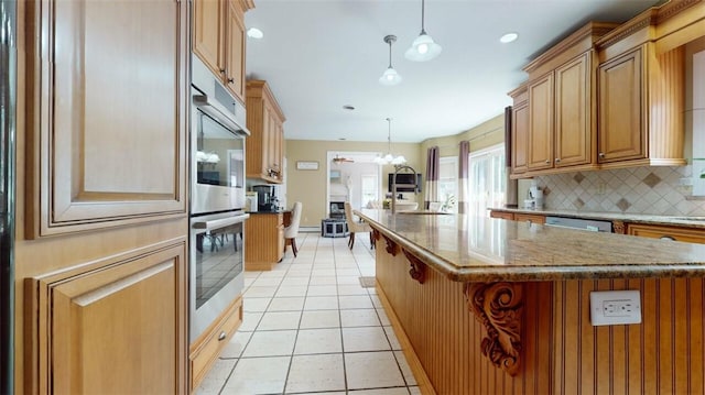 9 Roselawn Rd, Highland Mills, NY 10930 - kitchen with stainless steel appliances, decorative backsplash, light tile patterned flooring, dark stone counters, and a center island