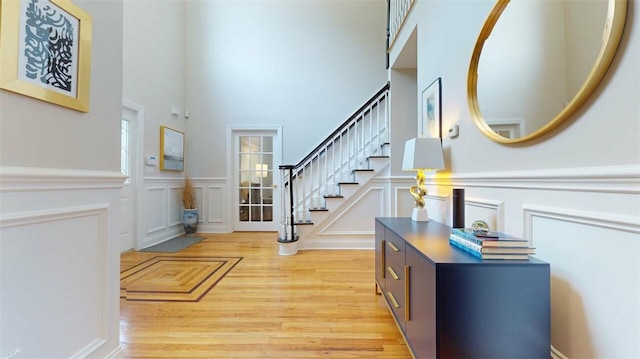 9 Roselawn Rd, Highland Mills, NY 10930 - entryway with light wood-type flooring, a decorative wall, a towering ceiling, stairs, and a wainscoted wall