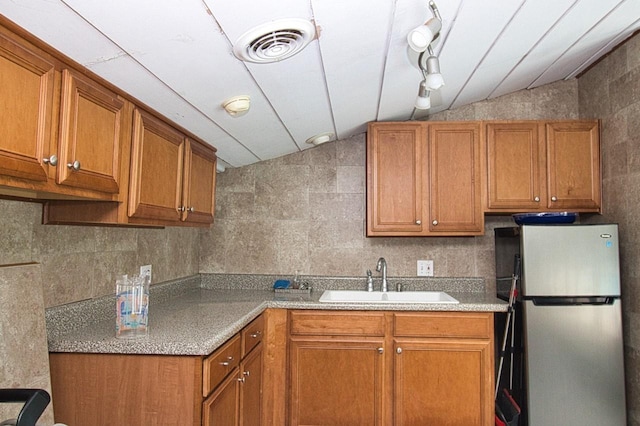 9 Roselawn Rd, Highland Mills, NY 10930 - kitchen with freestanding refrigerator, brown cabinetry, vaulted ceiling, light countertops, and tile walls