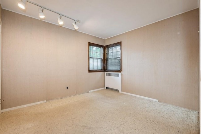 709 Seabury Ave, Franklin Square, NY 11010 - unfurnished room with radiator heating unit, track lighting, and carpet