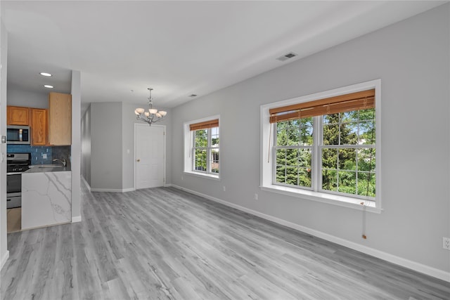 1410 Half Moon Bay Dr, Croton-On-Hudson, NY 10520 - unfurnished living room featuring a chandelier, light wood-type flooring, and recessed lighting
