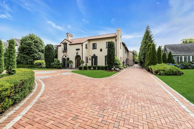 259 Lakeview Ave W, Brightwaters, NY 11718 - mediterranean / spanish house with a chimney, stucco siding, a front yard, and decorative driveway