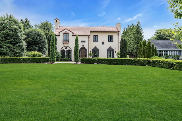 259 Lakeview Ave W, Brightwaters, NY 11718 - mediterranean / spanish house featuring a chimney, a tiled roof, a front lawn, and stucco siding