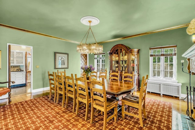 259 Lakeview Ave W, Brightwaters, NY 11718 - dining room with radiator, ornamental molding, a chandelier, and wood finished floors