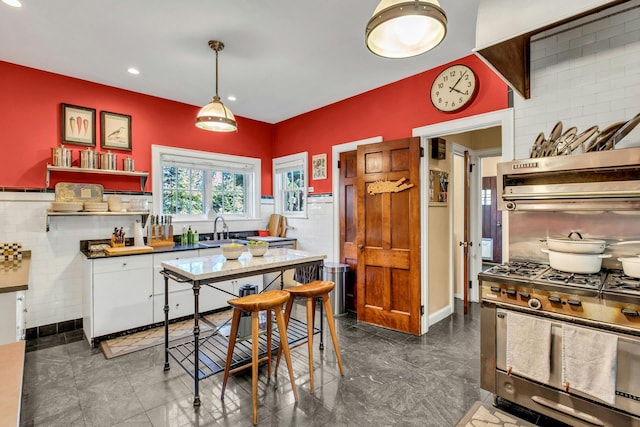 259 Lakeview Ave W, Brightwaters, NY 11718 - kitchen featuring tasteful backsplash, stainless steel range with gas stovetop, hanging light fixtures, white cabinetry, and open shelves