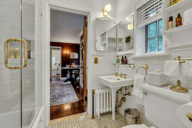 259 Lakeview Ave W, Brightwaters, NY 11718 - bathroom featuring radiator, combined bath / shower with glass door, ensuite bathroom, and tile walls