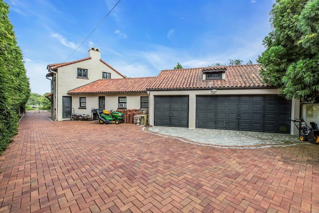 259 Lakeview Ave W, Brightwaters, NY 11718 - mediterranean / spanish house featuring stucco siding, a tile roof, an attached garage, and decorative driveway