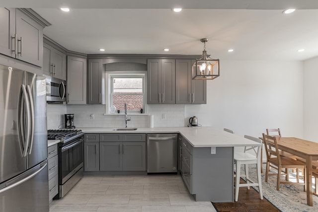 57 7th St, Pelham, NY 10803 - kitchen featuring stainless steel appliances, gray cabinets, a peninsula, a breakfast bar, and recessed lighting